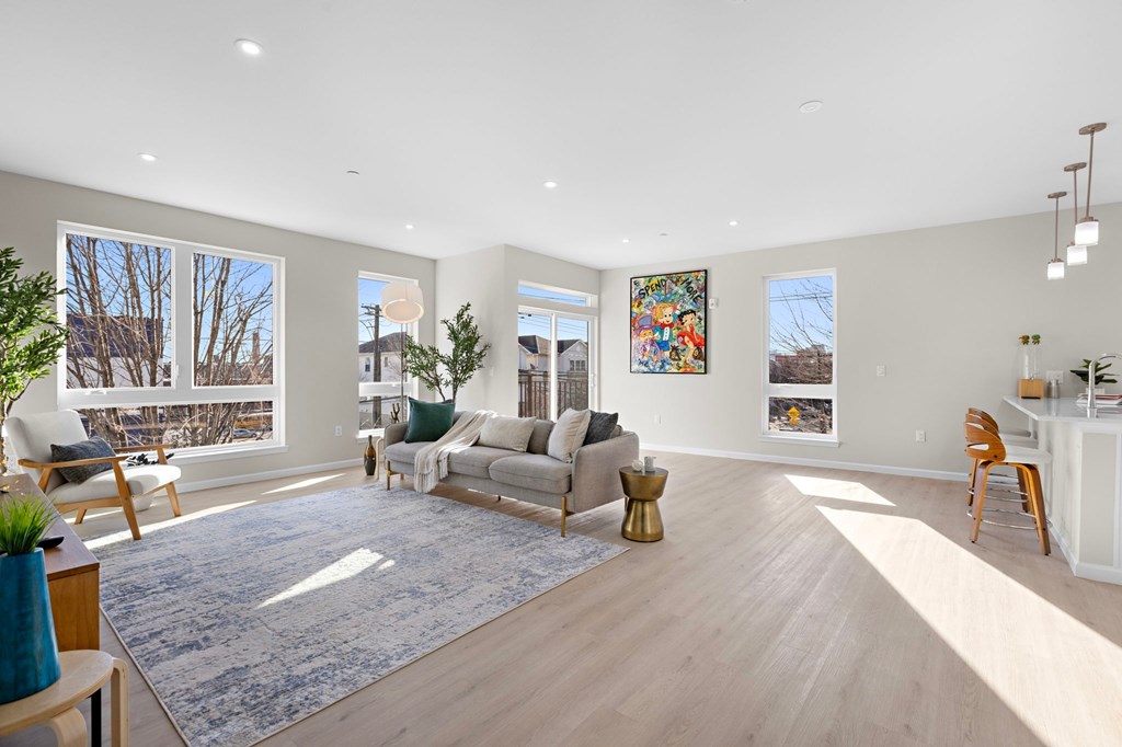 A living room with a couch, chairs, and a rug.