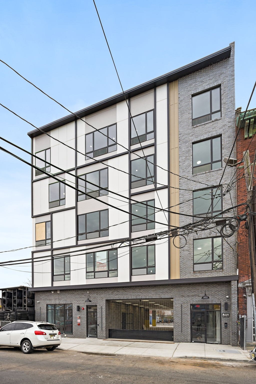 A modern building with a white car parked in front.