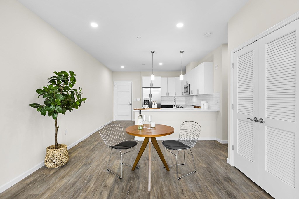 A room with a round table and chairs and a potted plant.