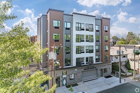 A modern apartment building with a sign that reads "Apartments".