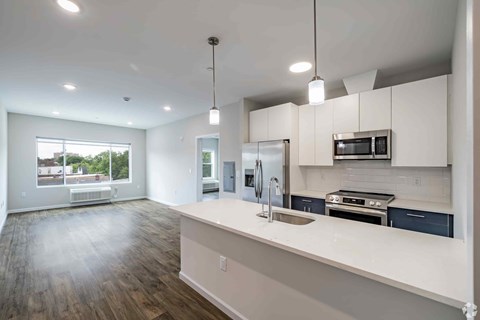 A kitchen with white cabinets and a wooden floor.