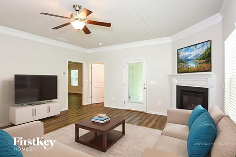 A living room with a television, a fireplace, and a painting on the wall.