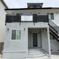 A grey building with a black awning and a sign that says "Available for Rent".
