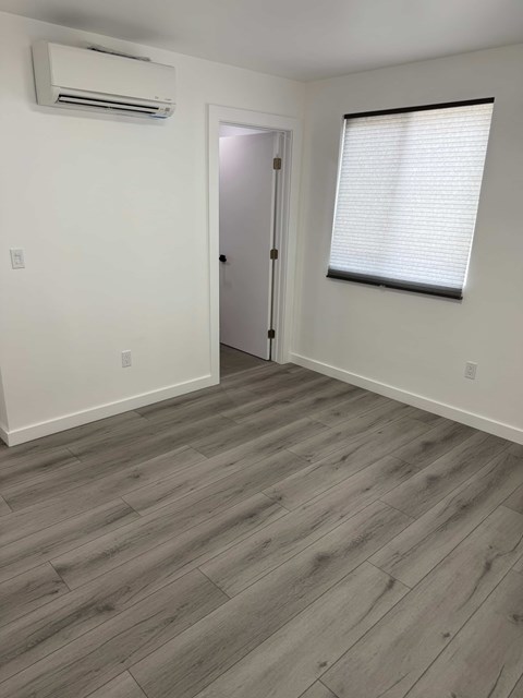 A room with a wooden floor and a door.