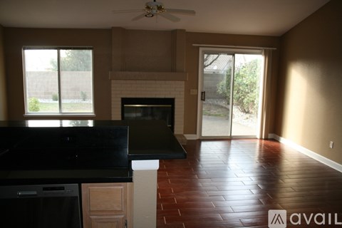A kitchen with a black counter top and a fireplace.