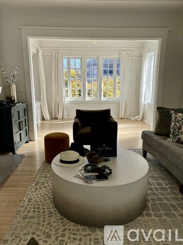 A living room with a round table in the center and a couch to the right.