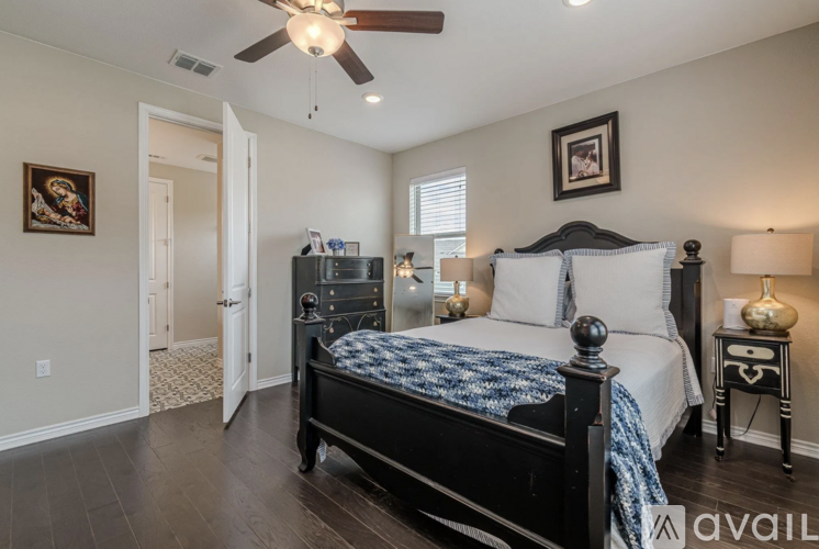 A bedroom with a large bed and a ceiling fan.