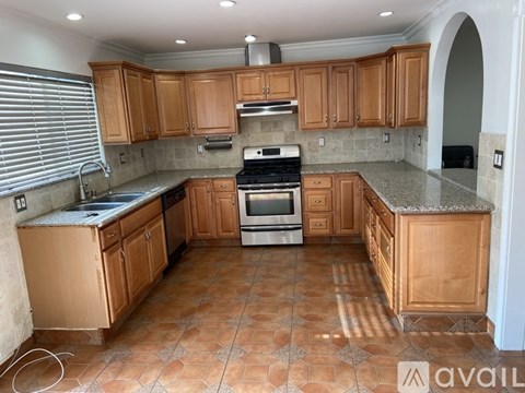 A kitchen with wooden cabinets and a tiled floor.