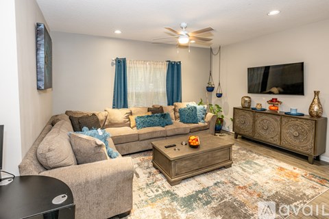 A living room with a couch, a coffee table, and a rug.