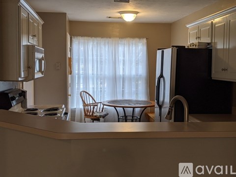 A kitchen with a table and chairs by a window.