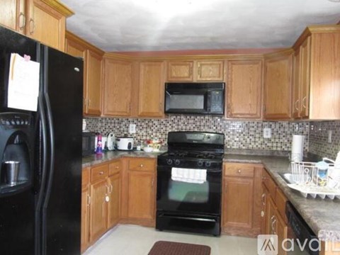 A kitchen with wooden cabinets and black appliances.
