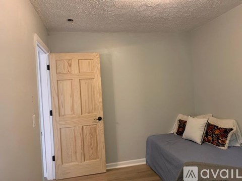 A bedroom with a bed and a wooden door.