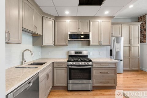 A kitchen with a stove top oven and a refrigerator.