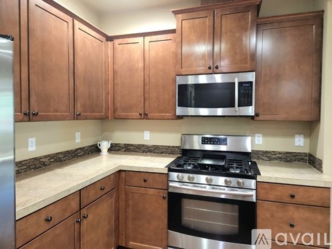 A kitchen with wooden cabinets and a stainless steel oven.