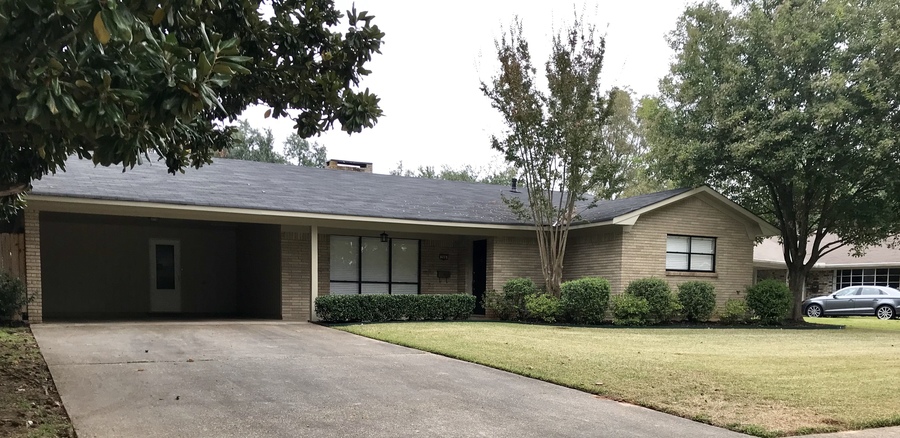 A house with a grey roof and a grey car parked in front.