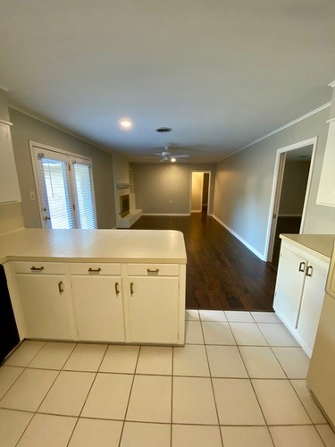 A kitchen with white cabinets and a tiled floor.