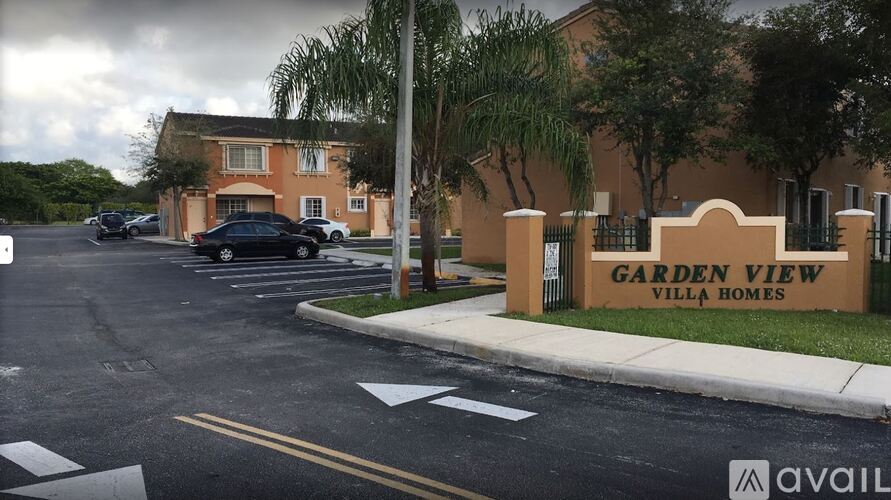 A sign for Garden View Villa Homes is in front of a building.