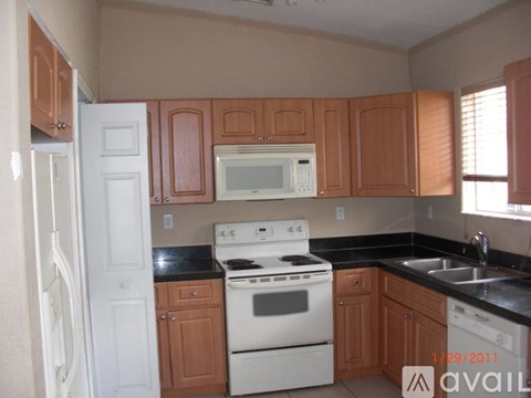 A kitchen with a white stove and wooden cabinets.