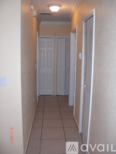A hallway with two doors and a wall-mounted light fixture.