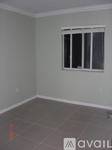 A room with a window and tiled floor.