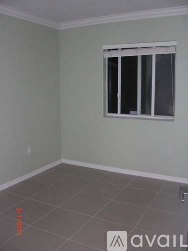 A room with a window and tiled floor.