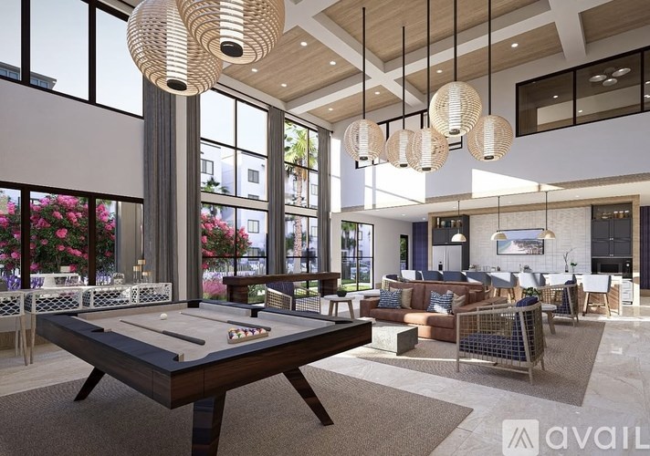 A billiard table is in the middle of a spacious room with a pool table and a couch.