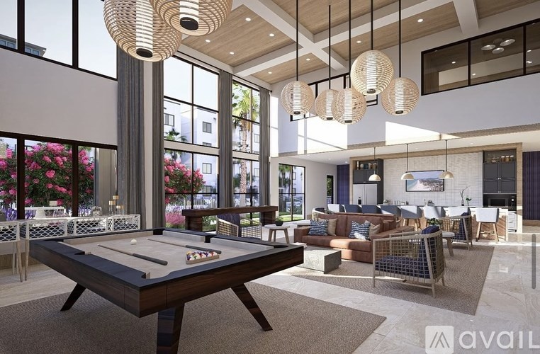 A pool table is in the middle of a room with a lot of windows.