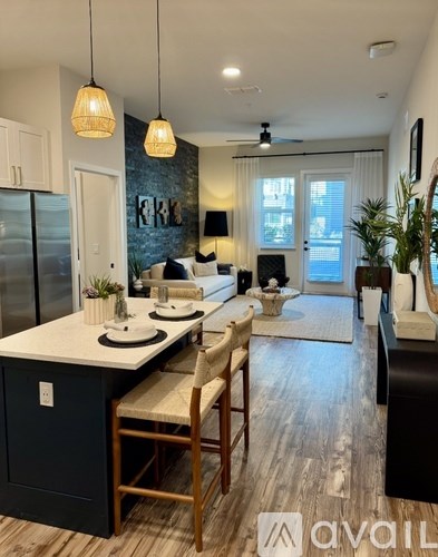 A modern kitchen with a dining area and a living room in the background.