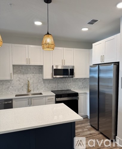 A kitchen with white cabinets and a black countertop.