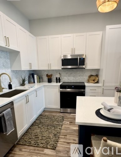 A kitchen with white cabinets and a black dishwasher.