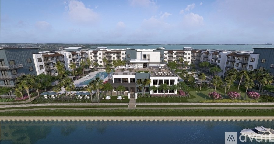 A row of white buildings with a body of water in front.