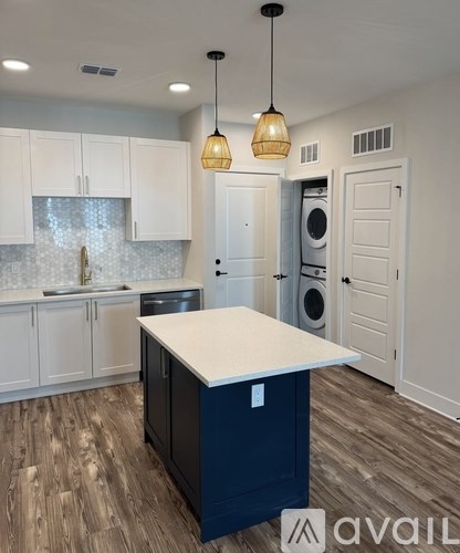 A kitchen with a blue island and white cabinets.