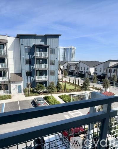 A view of a residential area with apartment buildings and cars parked in the driveways.