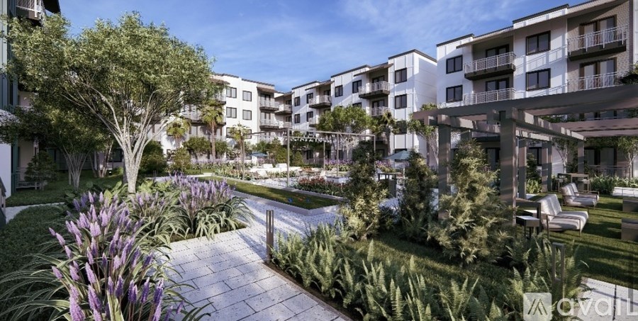 A modern apartment complex with a landscaped garden in the foreground.