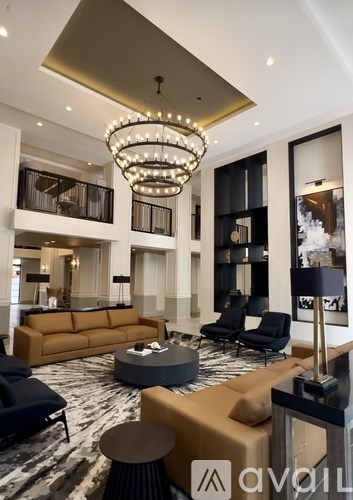 A modern living room with a large chandelier and a variety of seating options.