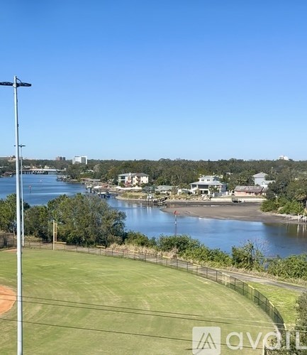 A view of a beachfront with a body of water, buildings, and a clear sky.