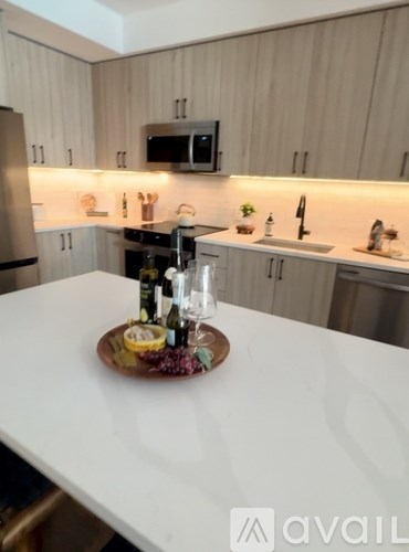 A kitchen with a white countertop and a wooden tray with food and drinks on it.