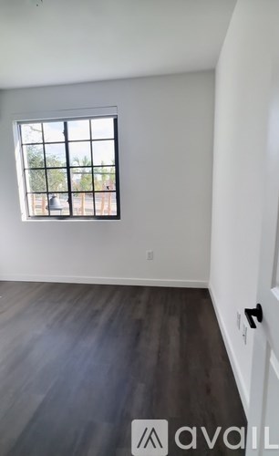 A room with a window and wooden flooring is available for rent.