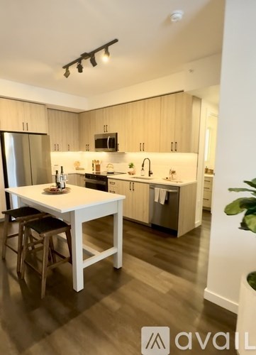 A kitchen with a white table and wooden cabinets.