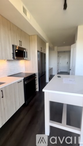 A kitchen with white cabinets and a black fridge.