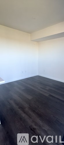 A room with a dark wooden floor and white walls.