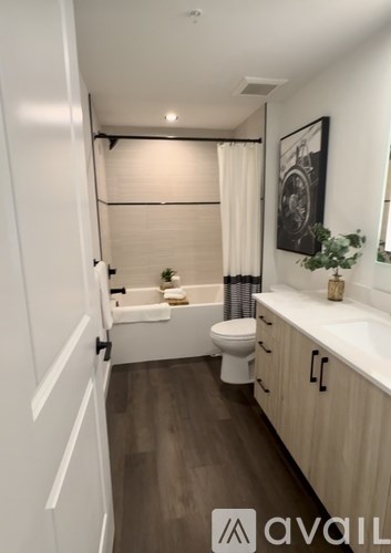 A bathroom with a toilet, sink, and a plant.