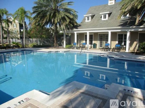 A large swimming pool in front of a house with a sign that says "available".