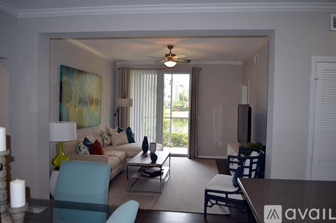 A living room with a couch, chairs, and a painting on the wall.