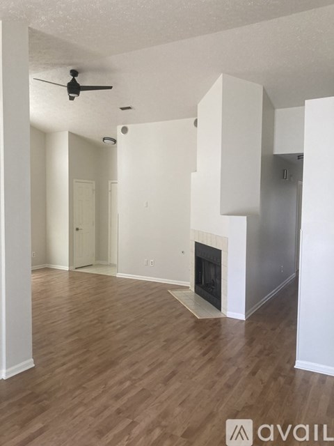 A room with a fireplace and wood flooring.