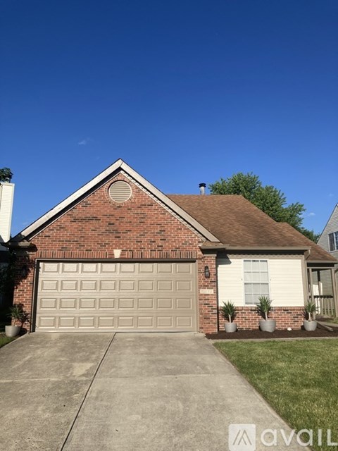 A house with a brick facade and a brown roof.