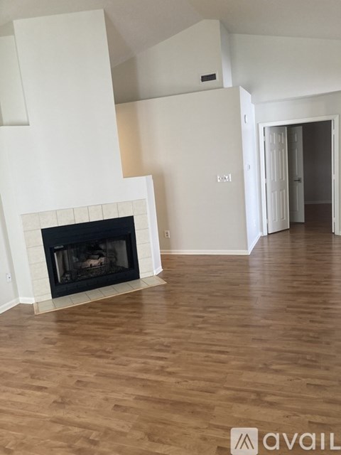 A living room with a fireplace and wooden floors.
