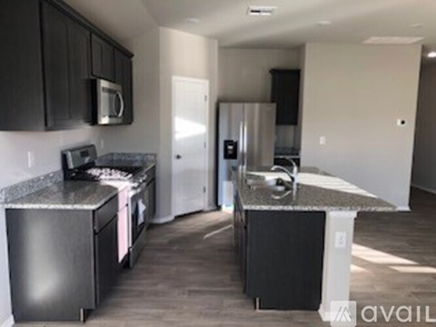 A kitchen with black cabinets and a granite counter top.
