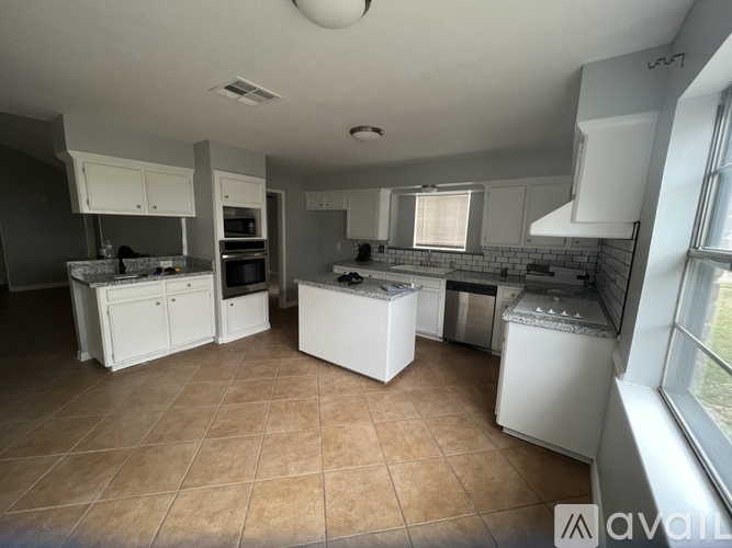 A kitchen with white appliances and cabinets.
