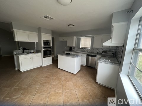 A kitchen with white appliances and cabinets.